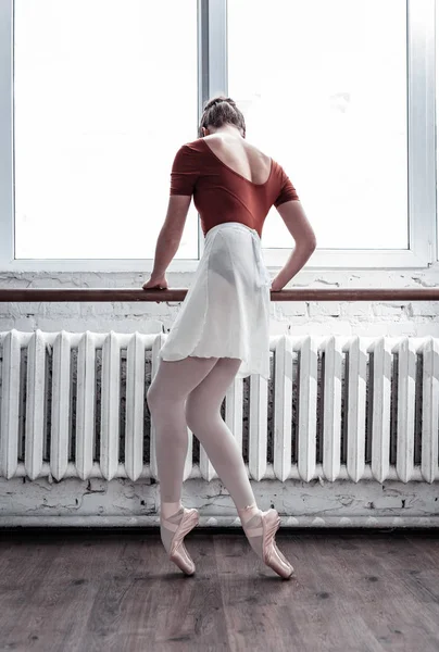 Niza joven bailarina profesional sosteniendo la barra — Foto de Stock