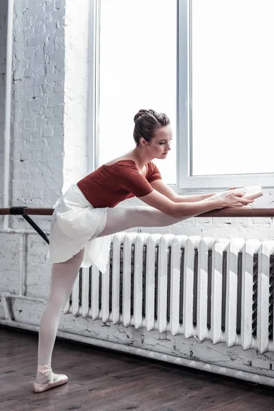 Attraktive, gut aussehende Frau, die ihre Flexibilität trainiert — Stockfoto