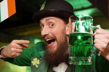 Koyu renk saçlı sakallı genç adam barda kutluyor bir masal cini kostümü