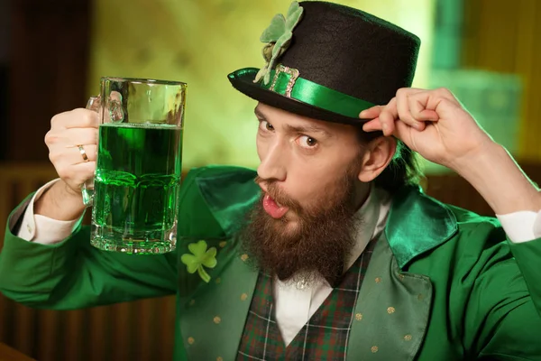 Jeune homme barbu aux cheveux foncés dans un chapeau de lutin avec un look trèfle diverti — Photo