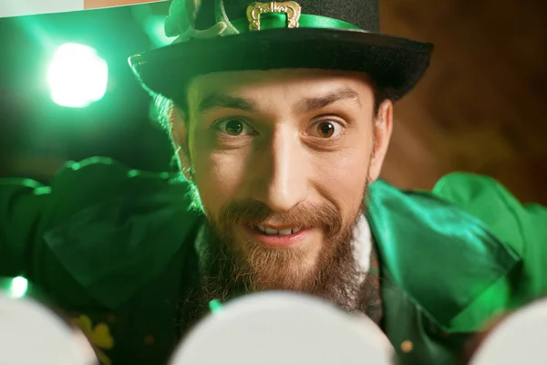 Bruno barbuto giovane con un cappello leprecauno che sembra felice — Foto Stock