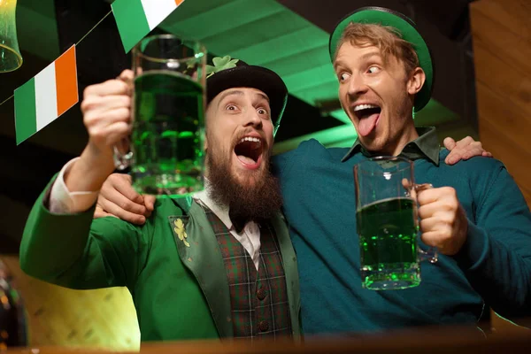 Темноволосый бородатый молодой человек в шляпе лепрекона и его друг, выглядящий пьяным — стоковое фото