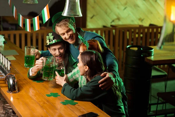 Compañía de buenos amigos pasando un buen rato en el pub irlandés — Foto de Stock