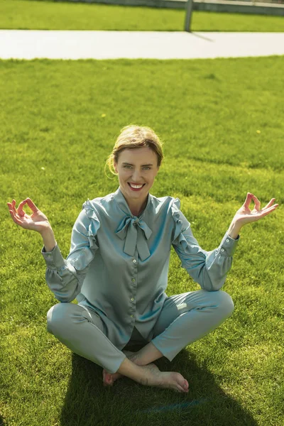 Suerte agradable dama haciendo yoga en la hierba —  Fotos de Stock