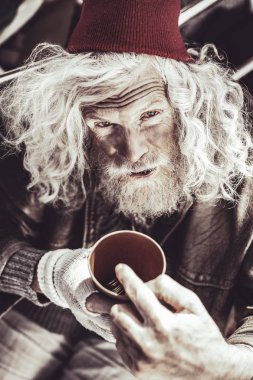 Kupası para ile tutarak ve günlük gelirini gösteren beyaz almsman.