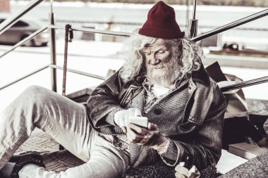 Uzanmış ve mesaj okumayı denerken baktılar dilenci.