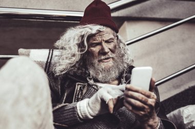 Yaşlı adam evsiz ekranda ailesinin fotoğrafları izlemek gibi arıyorsunuz.