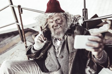 Videoda telefonla konuşurken gesticulating yaşlı evsiz adam.