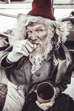 Yemek ve kamera üzerinden seyir kurnaz bakışla yaşlı serseri.