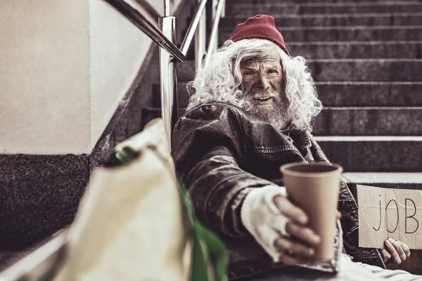 Dakloze ouderen aanbieden zijn cap waarvan hij houdt in één hand voor aalmoes. — Stockfoto