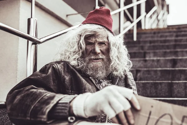 Vuile dakloze man op zoek naar de camera met twijfel. — Stockfoto