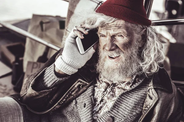 Old almsman finding new phone and deciding to call to someone.