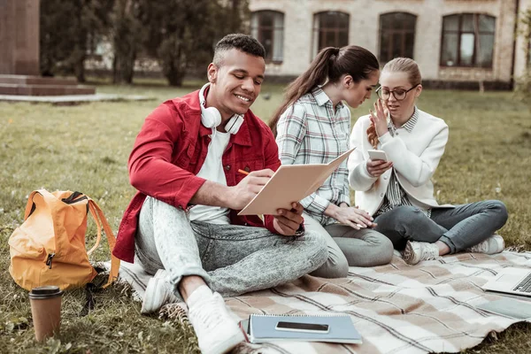 Vrolijke internationale man maken van aantekeningen in de beurt — Stockfoto