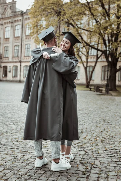 Cheerful international students wearing uniform for graduation — Stock Photo, Image