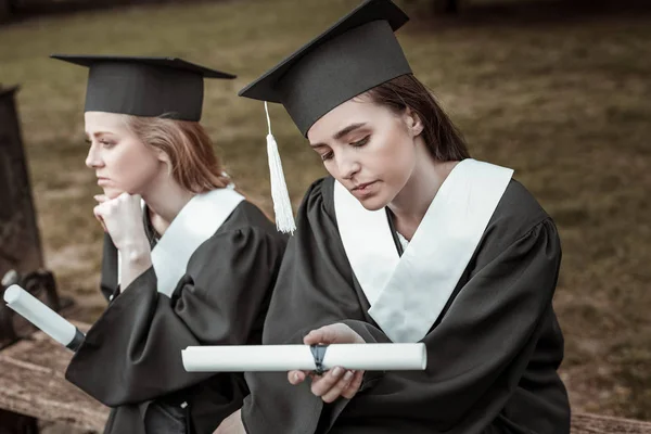 Two thoughtful females waiting for graduation party — Stock Photo, Image