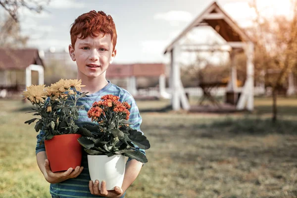 Vörös hajú fiú kék póló könyv virág — Stock Fotó