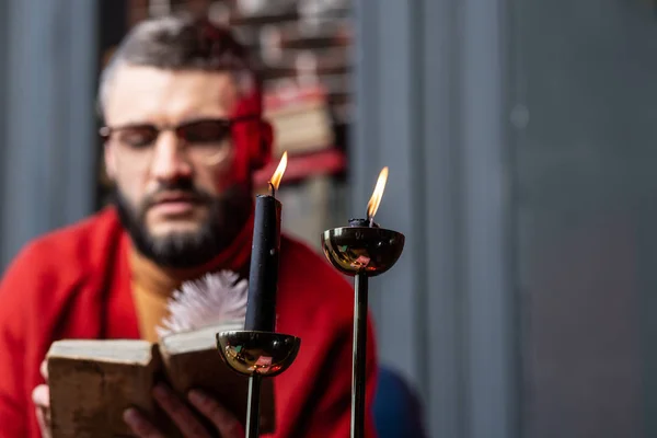 Due candele accese in piedi sul tavolo vicino al libro di lettura diviner — Foto Stock