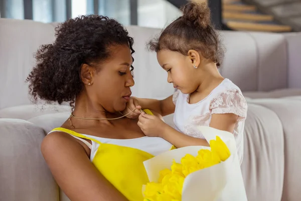 Attente krullend harige vrouwelijke persoon luisteren naar haar kind — Stockfoto