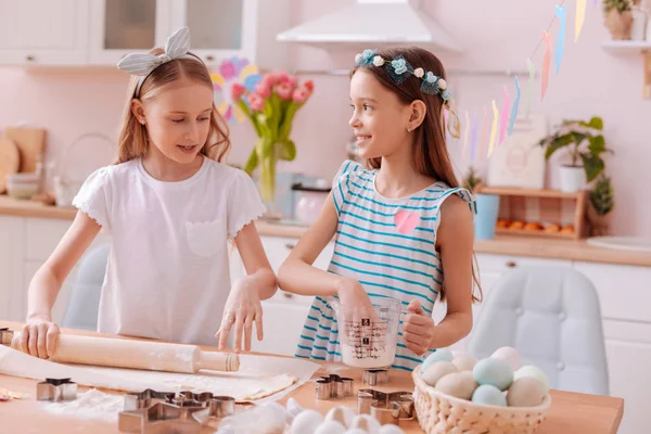 Adolescentes encantadores siguiendo la receta para hornear galletas —  Fotos de Stock