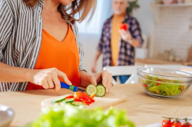 Çizgili giyen kadın kesme sebze salatası için bluz