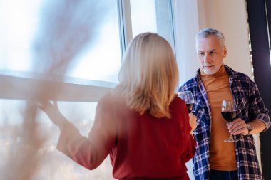 Evde pencere duran ve kırmızı şarap içme işadamları