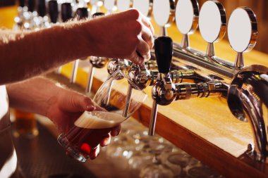Barmen dökülen karanlık bira cam içine yakın çekim