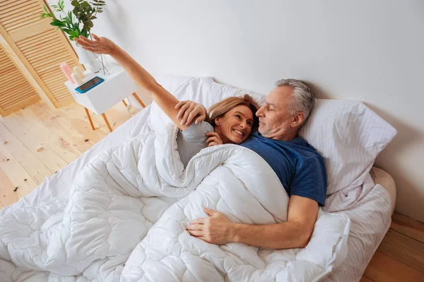 Beaming esposa sorrindo amplamente ao acordar perto de seu homem — Fotografia de Stock