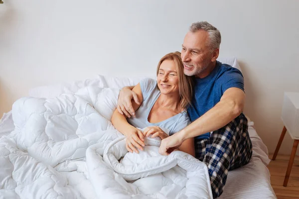 Marido barbudo con pijamas abrazando a su encantadora mujer — Foto de Stock