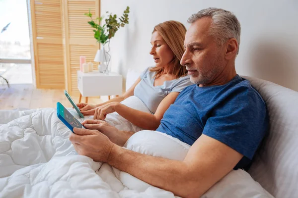 Marido e esposa atraente verificando a taxa de câmbio em tablets — Fotografia de Stock