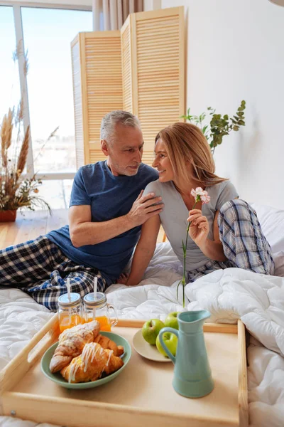 Marido canoso mirando a su esposa radiante mientras desayunaba —  Fotos de Stock
