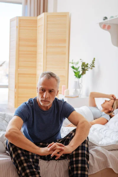 Volwassen man dragen van pyjama's gevoel betrokken zitten in de buurt van vrouw — Stockfoto