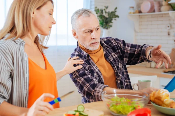 Wife calming her husband feeling angry after reading e-mail