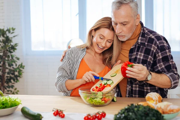 Marito abbracciare sua moglie cucinare insalata sana per il pranzo — Foto Stock