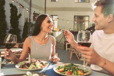 Bir elinde kırmızı şarap ile kısa saçlı erkek gülümseyen