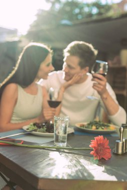 Esmer güzel kız yakışıklı erkek şarap tutarken okşama