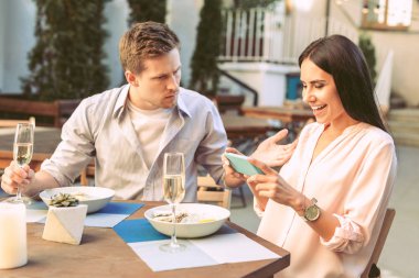 Neşeli uzun saçlı kadın onun yemek smartphone ile fotoğraf yapma