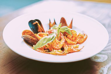 Seramik plaka üzerinde yalan deniz ürünleri ile parlak ve renkli makarna