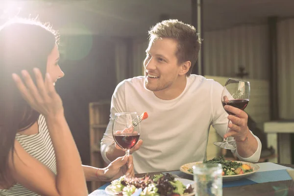 Novio comunicativo con rastrojo ligero comiendo ensalada y hablando con chica — Foto de Stock