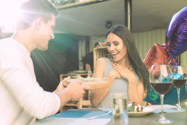 Joyful dark-haired young woman being shocked and pleased with gift — Stock Photo, Image