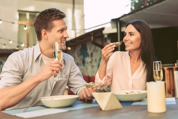 陽気な若いカップル高価な海カキを食べると飲む — ストック写真