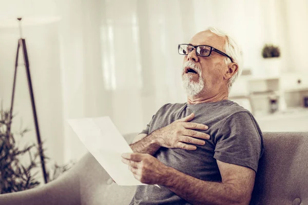 У шокованого чоловіка серцевий напад після читання паперів — стокове фото