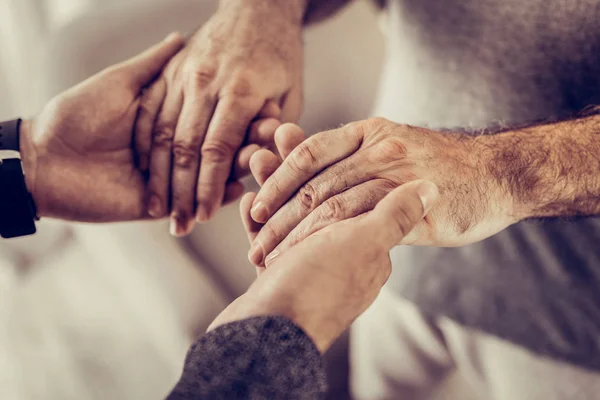 Close-up photo of two male holding hands in hands — Stock Photo, Image