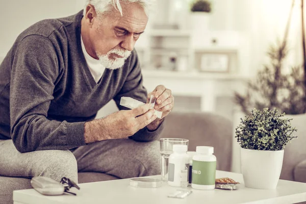 Retrato de anciano enfermo sosteniendo píldoras caja en las manos — Foto de Stock