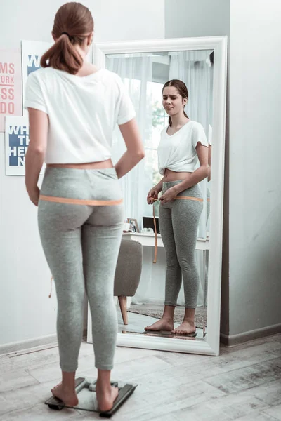 Νεαρή γυναίκα λήψη μετρήσεων, ενώ σε μια δίαιτα — Φωτογραφία Αρχείου