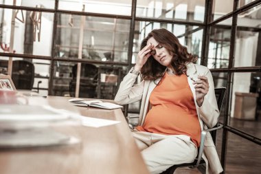 Zor duygusal ve fiziksel durumda olmaktan rahatsız uzun saçlı kadın