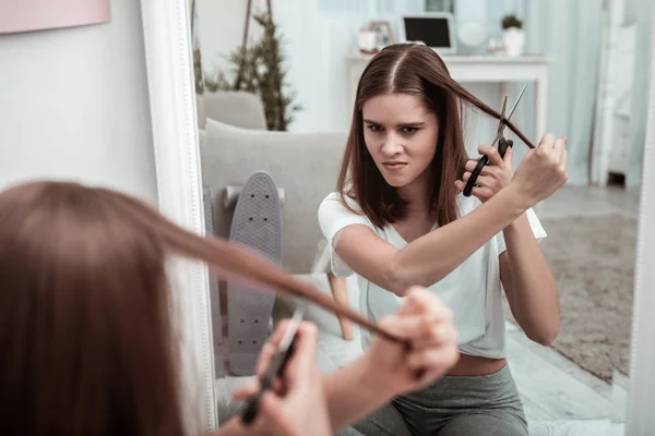 Kobieta próbuje obciąć włosy, sama — Zdjęcie stockowe