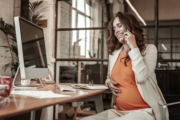 Trevlig skrattande gravid kvinna har positiva konversation — Stockfoto