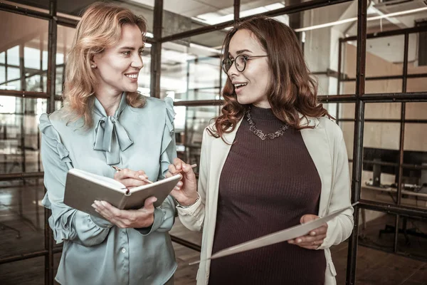 Dunkelhaarige, strahlende Dame mit klarer Brille unterhält sich rege — Stockfoto