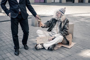 Boş Kupası taşıyan ve sadaka için bekleyen ışınlama uzun saçlı sefil adam