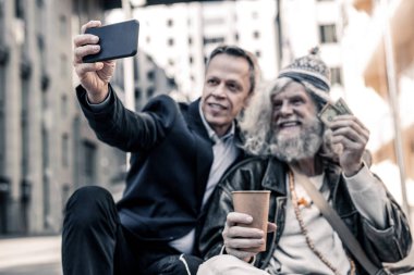 Soğuk yerde oturan düzensiz uzun saçlı işsiz adam